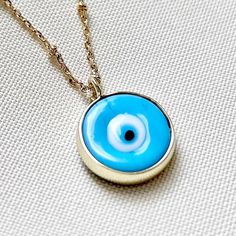 DETAILS: Handmade necklace 18k Gold Filled Necklace with Gold Filled Charm 🧿 Chain size 14" + 2 inchs chain. CARE: Try to avoid your jewelry coming into contact with perfumes, skin and hairs products Store your jewelry in a dry, airtight place. Made with Love 💙 Evil Eye Round Pendant Necklace Gift, Amulet Eye Necklace Gift, Eye-shaped Amulet Necklace As Gift, Everyday Evil Eye Pendant Necklace, Symbolic Evil Eye Necklace For Gift, Symbolic Evil Eye Necklace As Gift, Evil Eye Charm Necklace With Round Pendant For Gifts, Evil Eye Charm Necklace With Round Pendant As Gift, Blue Charm Necklace Gift - Tarnish Resistant