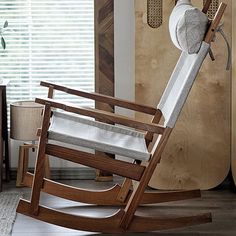 a rocking chair in front of a wooden door and window with blinds on the outside