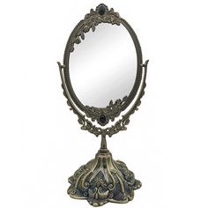 an antique looking mirror with ornate designs on the top and bottom edge, is shown against a white background