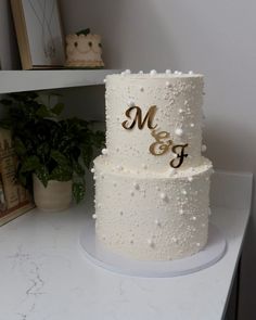 two tiered wedding cake with pearls and monogrammed initials