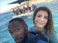 a man and woman taking a selfie in the water