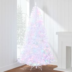 a white christmas tree with multicolored lights is in the corner of a room