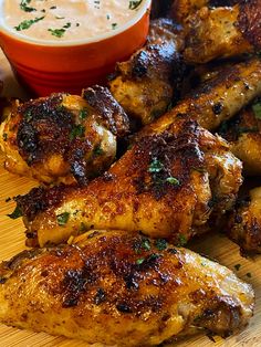 chicken wings and dipping sauce on a cutting board