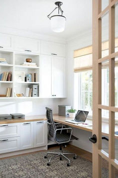 a home office with white cabinets and an open window