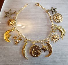 "This celestial moon stars and sun inspired bracelet has 12 gold tone charms. The charms are from finding companies that have discontinued some of the the charms. So when I have used all of the discontinued charms there will be no more bracelets exactly like this one. However, I do have many charms with moon stars and suns so I can create a bracelet similar to the one shown in the picture. I buy the gold tone Figaro bracelet new from a findings company in New York in bulk length and cut it to 7\ Cheap Bohemian Beaded Necklaces For Festivals, Cheap Gold Bracelets With Vintage Charm, Sun Bracelet, Indie Jewelry, Estilo Hippie, Victorian Vintage, Jewelry Accessories Ideas, Dope Jewelry, Recycled Fashion