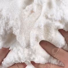 two hands are holding some white powder