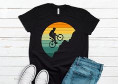 You Will Love this Unique and Cool Mountain Biker T-shirt. Makes A Great Gift For Mountain Bikers! Please refer to the listing pictures for the size guide and other color options. * Bella-Canvas Short Sleeve Unisex T-Shirt * Design is printed on One side * 100% combed and ring-spun cotton (Heather colors contain polyester) * Fabric weight: 4.2 oz./yd.² (142 g/m²) * Pre-shrunk fabric * Side-seamed construction * Shoulder-to-shoulder taping * Design is professionally PRINTED using commercial grade equipment for a long lasting shirt. * Soft and High-Quality Fabric ►► FONTS & DESIGN * Design size and placement is approximate. Each shirt is custom hand made. Exact size & placement of design may vary. * Due to monitor differences, actual colors may vary slightly from what appears online. * Pleas Graphic Tee T-shirt With Crew Neck For Cycling, Graphic Cycling T-shirt With Crew Neck, Graphic Tee With Crew Neck For Cycling, Sporty Graphic Print T-shirt For Cycling, Black Short Sleeve T-shirt For Cycling, Graphic Print Short Sleeve T-shirt For Cycling, Crew Neck Cotton T-shirt For Cycling, Cotton Crew Neck T-shirt For Cycling, Black Biker T-shirt For Outdoor Activities