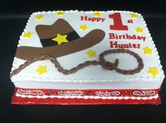 a birthday cake with a cowboy hat and lasso on it