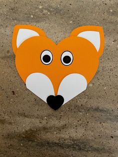 an orange and white paper cut out of a fox's head with eyes wide open