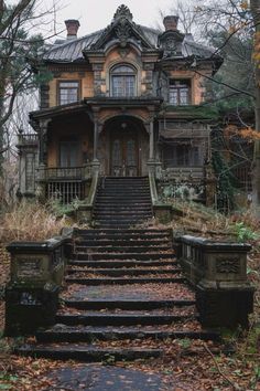 an old house in the woods with stairs leading up to it