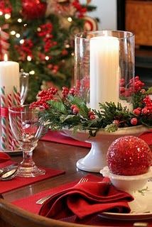 a christmas table setting with candles and red napkins