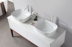 two white sinks sitting next to each other on top of a counter