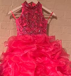 The elegant and sophisticated Sugar Kayne C328 Girls Preteens Pageant Dress boasts a dazzling halter neckline and full ruffle ball gown skirt with a crystal bodice, perfect for making a memorable fashion statement. Be sure to steal hearts in this organza ballgown. Shine like a diamond with the sequin and stones bejeweled bodice and high neck detail, complete with voluminous layers of organza on the skirt. Colors: Barbie Pink, Cinderella Blue, Yellow Sizes: 2, 4, 6, 8, 10, 12, 14, 16 (Sizes 2-6 d Glamorous Tiered Evening Dress With Ruffles, Gala Gown With Ruffled Skirt For Prom Season, Glamorous Halter Dress With Fitted Bodice For Wedding, Glamorous Ball Gown With Ruffles And Fitted Bodice, Fitted Bodice Halter Dress For Prom Season Parties, Fitted Bodice Halter Dress For Prom Party, Halter Dress With Fitted Bodice For Prom Season Party, Fitted Bodice Halter Dress For Prom Season, Sleeveless Pageant Dress For Prom Season