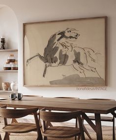 a dining room table with chairs and a painting on the wall above it that has an image of a horse