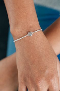 CBM-310 Dainty but enduring, this .925 sterling silver adjustable bracelet affixes a circular charm with your loved one's solidified ashes to a delicate, yet sturdy chain. Dimensions & Details:Setting: 8mmChain: .925 sterling silver 1.8mm rounded box chain | adjustable up to 8" All dimensions are approximate and may vary slightly with every casting. This piece can accommodate up to four characters of engraving, including spaces and simple symbols, along the back of its setting. Examples of the f Minimalist Adjustable Sterling Silver Oyster Bracelet, Sterling Silver Round Bracelet With Birthstone For Anniversary, Minimalist Sterling Silver Jewelry With Oyster Bracelet, Dainty Sterling Silver Oyster Bracelet, Minimalist Sterling Silver Oyster Bracelet, Sterling Silver Oyster Bracelet For Everyday, Adjustable Everyday Jewelry With Polished Finish, Adjustable Polished Finish Jewelry, Minimalist Sterling Silver Diamond Bracelet