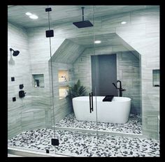 a white bath tub sitting inside of a bathroom next to a walk in shower stall