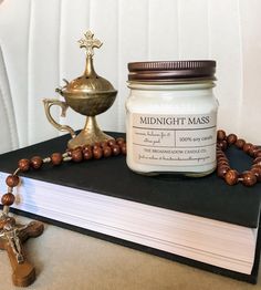 a candle and rosary on top of a book