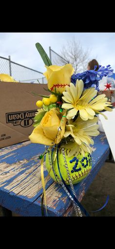 a bouquet of flowers sitting on top of a blue bench next to a cardboard box