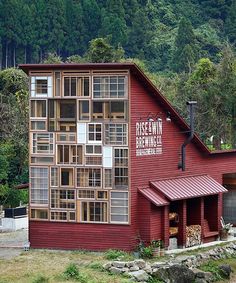 a red building with lots of windows on the side of it and trees in the background