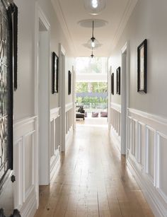 an image of a hallway with white walls and wood floors