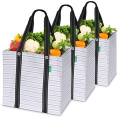 three grocery bags filled with vegetables and carrots, all lined up in the same pattern