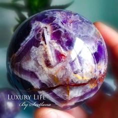 a person holding a purple marble ball in their hand