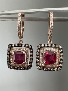 "Offered here is a beautiful pair off earrings with chocolate and vanilla diamonds set in rose gold that feature a treated ruby. This set would make a great gift to surprise a loved one or add this stunning pair to your own collection. The sparkle on these is so gorgeous-especially in the sunlight, that's when they really light up! These earrings always get compliments!  The earrings feature a treated ruby in a halo of sparking diamonds set in 14k rose gold. These are stamped 14k on the posts al Luxury Red Diamond Earrings, Luxury Rose Gold Earrings With Rose Cut Diamonds, Luxury Rose Gold Earrings With Single Cut Diamonds, Fine Jewelry Rose Gold Diamond Earrings With Rose Cut, Rose Gold Diamond Earrings With Gemstone, Rose Gold Rose Cut Diamond Earrings, Formal Rose Gold Ruby Earrings, Luxury Red Diamond Earrings As Gift, Luxury Red Diamond Earrings For Gift