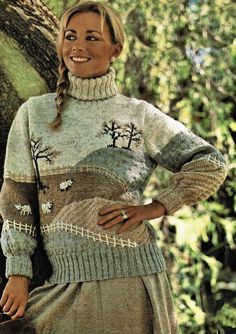 a woman wearing a sweater and skirt with trees on the side, in front of a tree