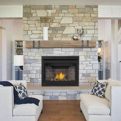 a living room with two couches and a fire place in the middle of it