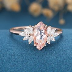 an oval cut pink diamond ring with three pear shaped diamonds