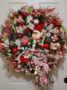 a christmas wreath with candy canes, candies and a santa clause on it