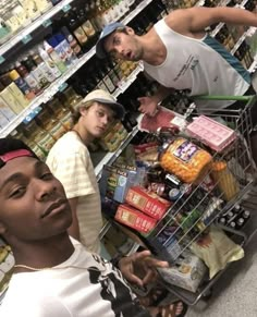 three men standing in front of a grocery cart