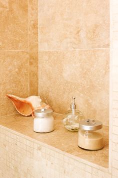 a bathroom with two soap dispensers and a seashell on the counter