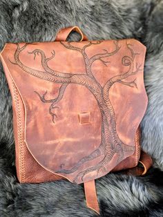 Twisted Tree Leather Backpack / Purse / Convertible Bag This listing is to order your own similar spectacular creation. This is a beautiful handmade, hand stitched, one of a kind Convertible Leather Backpack / Shoulder Bag / Messenger Bag / Satchel / Crossbody Briefcase. It is made from extremely durable and rustic Kodiak Stone Oil leather. It has beautiful color variation as well as strong water resistance and perfect for lifelong use. The image is a free hand pyrographic drawing by us The bag Artisan Rectangular Backpack For Everyday Use, Artistic Brown Bag For Everyday Use, Artistic Brown Bags For Everyday Use, Handmade Nature-inspired Travel Bag, Everyday Artisan Handmade Satchel, Artisan Handmade Satchel For Everyday, Artisan Hand-stitched Satchel For Everyday Use, Handmade Brown Shoulder Bag Backpack, Handmade Standard Backpack For Travel