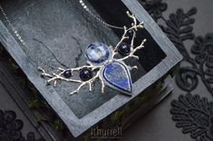 "HOLIDAY SHIPPING NOTICE: Kindly refer to the store policies for delivery estimates for your location: https://www.etsy.com/shop/ithuriell#policies Elaborate elven necklace than combines blue vibrancy of lapis lazuli with thunderstorm-blue of sodalite. Complemented with dark blue goldstone glass reminding of starry night sky. The very embodiment of \"something blue\", and a perfect adornment for those in love with ever-changing heavens. Lapis lazuli, sodalite, goldstone glass, polymerclay, Zinc- Blue Gemstone Celestial Necklace, Mystical Blue Pendant Necklace, Mystical Blue Pendant Jewelry, Blue Mystical Pendant Jewelry, Handmade Mystical Blue Jewelry, Mystical Blue Sterling Silver Necklace, Blue Sodalite Pendant Necklace, Handmade Celestial Sapphire Jewelry, Handmade Silver Sodalite Necklaces