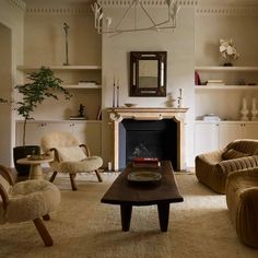 a living room filled with furniture and a fire place in the middle of a room