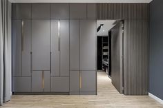 an empty room with grey cabinets and wooden floors