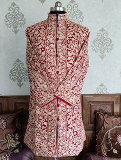 Kashmiri Jacket, Paisley Coat, Kashmiri Long Jacket Wrap yourself in the embrace of this elegant and cosy Kashmiri Woolen long Jacket designed with paisley embroidery. The coat comes in gorgeous melody with base colour as red, enveloped in white embroidery with complements of beige colour making any day; the day of your reign. The coat is crafted in 100% pure wool and invariably exudes charm, elegance, and luxury. Enjoy the distinctive intricate pattern with collar and the button line that comes Fitted Long Outerwear With Chikankari Embroidery, Long Fitted Nehru Jacket With Floral Embroidery, Fitted Long Nehru Jacket With Floral Embroidery, Long Floral Embroidered Fitted Nehru Jacket, Festive Long Outerwear With Chikankari Embroidery, Festive Long Outerwear With Resham Embroidery, Traditional Fitted Long Coat, Fitted Stand Collar Outerwear With Intricate Embroidery, Transitional Fitted Outerwear With Floral Embroidery