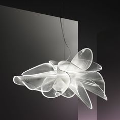 a white light hanging from the ceiling in front of a wall with lights on it