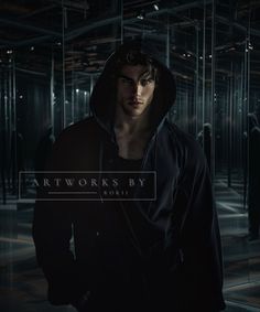 a man in a black hoodie is standing in front of mirrored walls and looking at the camera