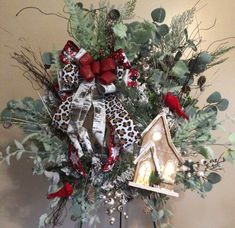 a christmas wreath with a birdhouse and red bow