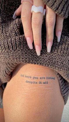 a woman's leg with a tattoo saying, i think you are living despite it all