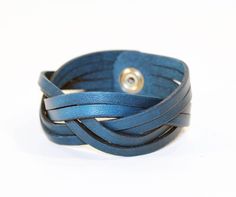 a close up of a blue leather bracelet