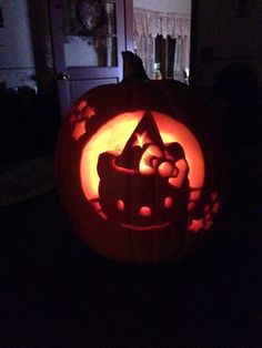 a carved pumpkin with an image of a car on it's face in the dark