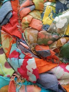 an assortment of different colored pieces of fabric with thread on them and some scissors in the middle