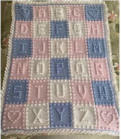 a crocheted blanket with the words happy birthday written in blue, pink and white