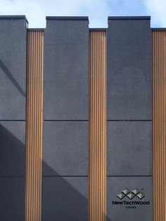 the side of a building with three tall wooden pillars on it's sides and a sign that reads new technology