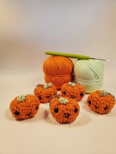 crocheted pumpkins and balls of yarn on a table