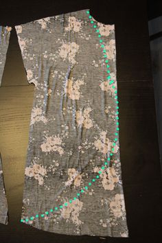 a piece of fabric with green dots on it sitting on top of a wooden table