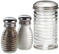 three glass salt and pepper shakers on a white background, one with a silver lid